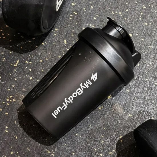 Zwarte MyBodyFuel shakebeker 400 ml op gymvloer na workout – duurzaam en vaatwasserbestendig