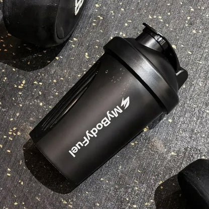 Zwarte MyBodyFuel shakebeker 400 ml op gymvloer na workout – duurzaam en vaatwasserbestendig